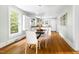 Bright dining room featuring a modern table with white chairs, hardwood floors, and an abundance of natural light at 107 E Hammond St, Durham, NC 27704