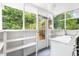 Bright laundry room with washer, dryer, shelving, and a view to the outdoors at 107 E Hammond St, Durham, NC 27704