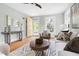 Open living room with hardwood floors, neutral furniture, natural light, and a yellow door at 107 E Hammond St, Durham, NC 27704
