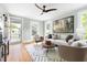 Bright living room with hardwood floors, neutral furniture, and natural light from large windows and an open doorway at 107 E Hammond St, Durham, NC 27704