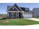 Charming two-story home featuring a well-manicured lawn, gray siding, and brick accents at 1091 Fairhaven Dr # 47, Mebane, NC 27302