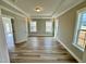 A bright living room with hardwood floors, tray ceilings, and three large windows at 1091 Fairhaven Dr # 47, Mebane, NC 27302