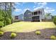 Beautiful backyard featuring green grass, manicured landscaping, and multi-story home at 1112 Valley Rose Way, Durham, NC 27712