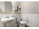 Well-lit half bath with pedestal sink, modern fixtures, and wood-look floors at 1112 Valley Rose Way, Durham, NC 27712