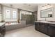 Relaxing bathroom with a soaking tub and large walk-in shower, featuring updated vanities and tiling at 1112 Valley Rose Way, Durham, NC 27712