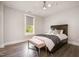 Cozy bedroom with a comfortable bed, ceiling fan, a window with a view, and beautiful wood-look flooring at 1112 Valley Rose Way, Durham, NC 27712