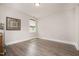 Bright bedroom featuring wood floors, neutral walls, base molding, and a sun-filled window at 1112 Valley Rose Way, Durham, NC 27712