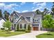 Attractive two-story home showcasing stone and gray siding, a well-kept lawn, a driveway, and a two-car garage at 1112 Valley Rose Way, Durham, NC 27712