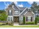 Charming two-story home featuring a stone facade, gray siding, wood accents, and a well-manicured front yard at 1112 Valley Rose Way, Durham, NC 27712