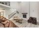 Bright living room with tall ceilings, a fireplace, wood floors, and staircase to the second floor at 1112 Valley Rose Way, Durham, NC 27712