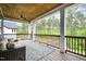 Inviting porch with wooded views, comfortable seating, a patterned rug and ceiling fan for relaxing outdoors at 1112 Valley Rose Way, Durham, NC 27712