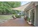 Charming back deck with outdoor seating and a shade sail, creating a relaxing spot to enjoy the serene backyard at 115 Standish Dr, Chapel Hill, NC 27517