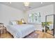 Bright bedroom featuring a comfortable bed, shuttered windows, and a full-length mirror at 115 Standish Dr, Chapel Hill, NC 27517