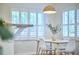 Bright dining room with modern light fixture, white chairs, and shuttered windows at 115 Standish Dr, Chapel Hill, NC 27517
