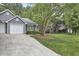 Charming home with a well-maintained driveway, mature trees, and lush green lawn, creating a serene setting at 115 Standish Dr, Chapel Hill, NC 27517