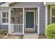 Inviting front porch with hanging floral baskets, a cozy chair, and a 'Welcome' mat, enhancing curb appeal at 115 Standish Dr, Chapel Hill, NC 27517