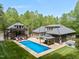 Aerial view of an inground pool with a separate guest house, gazebo, and beautiful landscaping at 120 Wood Lake Dr, Fuquay Varina, NC 27526