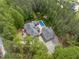 Aerial view of a private estate nestled among tall trees, featuring a pool and a three-car garage at 120 Wood Lake Dr, Fuquay Varina, NC 27526