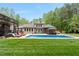 Beautiful backyard with an inground pool, gazebo, lounge chairs, guest house, and pristine landscaping at 120 Wood Lake Dr, Fuquay Varina, NC 27526