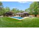 Expansive backyard with an in-ground pool, gazebo, guest house, and lush green lawn at 120 Wood Lake Dr, Fuquay Varina, NC 27526