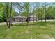 Secluded brick home surrounded by mature trees, featuring a long driveway and lush green lawn at 120 Wood Lake Dr, Fuquay Varina, NC 27526