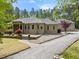 Expansive brick home featuring a gravel driveway, lush lawn, and inviting landscape design at 120 Wood Lake Dr, Fuquay Varina, NC 27526