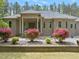 Charming brick home with a covered porch, flowering bushes, and meticulously maintained landscaping at 120 Wood Lake Dr, Fuquay Varina, NC 27526