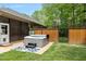 Backyard patio featuring a hot tub, privacy fence, and well-maintained lawn at 120 Wood Lake Dr, Fuquay Varina, NC 27526