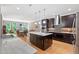 A kitchen with dark cabinets, stainless steel appliances, granite countertops and kitchen island at 120 Wood Lake Dr, Fuquay Varina, NC 27526