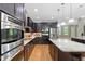 Kitchen features stainless steel appliances, custom cabinets, and a granite island with modern pendant lights at 120 Wood Lake Dr, Fuquay Varina, NC 27526