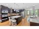 A gourmet kitchen featuring dark cabinets, stainless steel appliances, and a large granite island at 120 Wood Lake Dr, Fuquay Varina, NC 27526