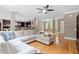 Open-concept living room with hardwood floors, a ceiling fan, and a large, comfortable sectional sofa at 120 Wood Lake Dr, Fuquay Varina, NC 27526