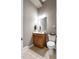 Neat powder room features a wood vanity, toilet, and a decorative mirror at 120 Wood Lake Dr, Fuquay Varina, NC 27526
