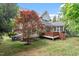 Backyard view of the house showcasing the deck, landscaping, and overall property features at 121 Cobblepoint Way, Holly Springs, NC 27540