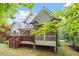 Backyard view of a home with a deck and a screened-in porch, surrounded by lush greenery at 121 Cobblepoint Way, Holly Springs, NC 27540