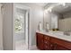 Bathroom with a double sink vanity, mirror, and a window providing natural light near the toilet at 121 Cobblepoint Way, Holly Springs, NC 27540
