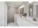 Bathroom with a marble tile shower, dual sinks, and white cabinets at 121 Cobblepoint Way, Holly Springs, NC 27540