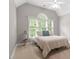 Bright bedroom with a large window and a cozy bed featuring a light-colored patterned comforter at 121 Cobblepoint Way, Holly Springs, NC 27540
