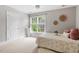 Bedroom with natural light and neutral decor, a cozy patterned bed and a small white dresser near the window at 121 Cobblepoint Way, Holly Springs, NC 27540