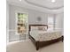 Comfortable bedroom featuring a large bed, soft carpet, and bright windows at 121 Cobblepoint Way, Holly Springs, NC 27540
