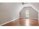 Bonus room featuring vaulted ceilings, hardwood floors, and a large window for natural light at 121 Cobblepoint Way, Holly Springs, NC 27540