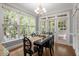 Bright dining room area with large windows, wood floors, and contemporary table and chairs at 121 Cobblepoint Way, Holly Springs, NC 27540