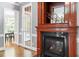 Elegant fireplace featuring wooden trim, dark marble, and a view to the dining area at 121 Cobblepoint Way, Holly Springs, NC 27540