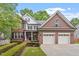 Charming brick home with a manicured lawn and an attached two-car garage at 121 Cobblepoint Way, Holly Springs, NC 27540