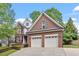 Charming brick home featuring a two-car garage and well-maintained landscaping at 121 Cobblepoint Way, Holly Springs, NC 27540