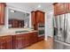 Modern kitchen featuring stone countertops, stainless appliances, and wood cabinetry at 121 Cobblepoint Way, Holly Springs, NC 27540