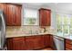 Traditional kitchen featuring wooden cabinets, granite counters, stainless steel fridge, and hardwood floors at 121 Cobblepoint Way, Holly Springs, NC 27540