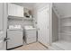 Functional laundry room equipped with modern washer, dryer, and storage shelves at 121 Cobblepoint Way, Holly Springs, NC 27540