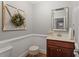 Cozy powder room with traditional wainscoting and a decorative vanity at 121 Cobblepoint Way, Holly Springs, NC 27540