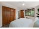 This bedroom features wood-look floors, access to an ensuite, closet, and view of nature at 1213 Blackwood Mountain Rd, Chapel Hill, NC 27516